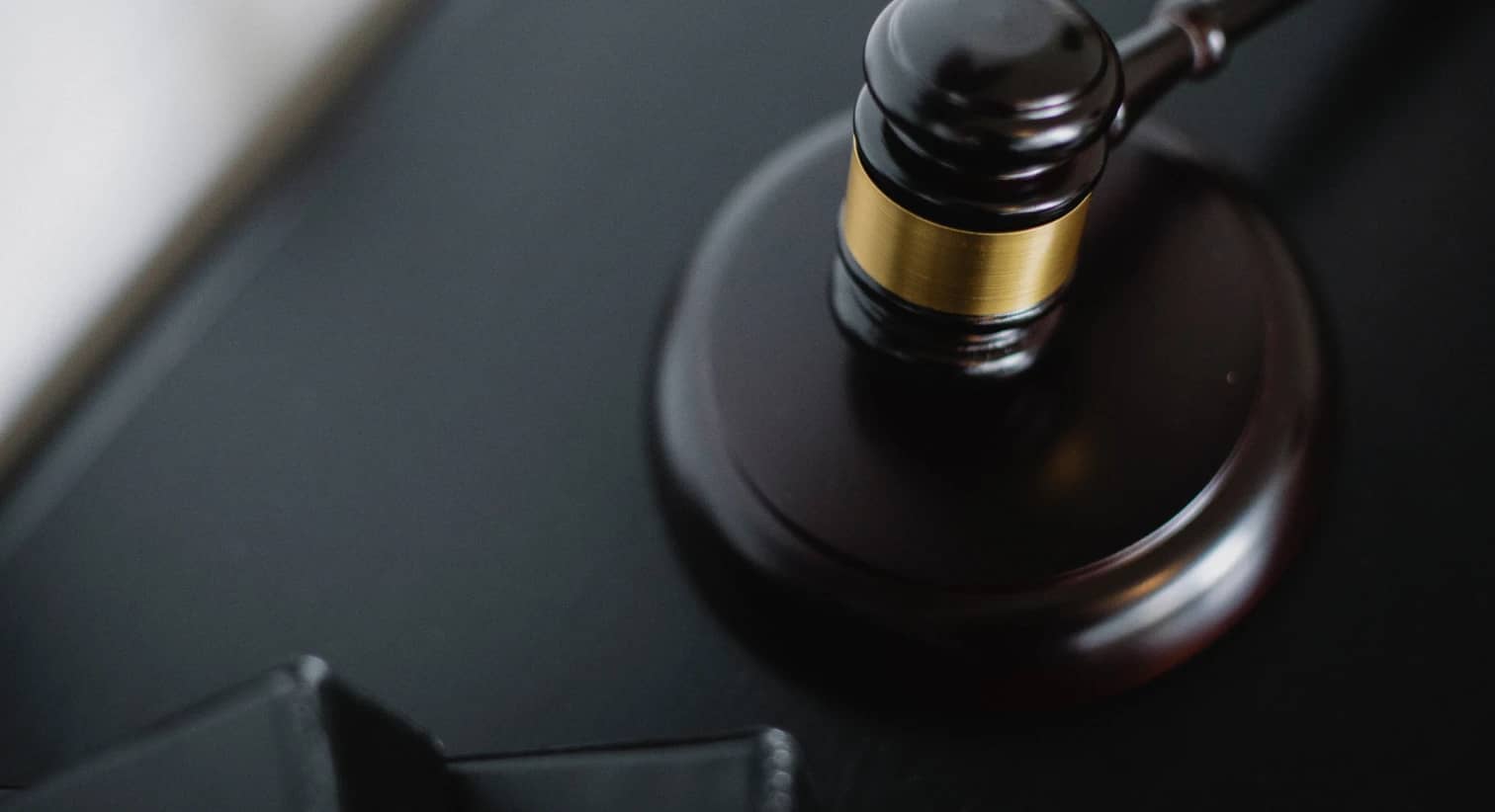 Imagem de fundo, contendo um malhete clássico, encontrado nos tribunais de justiça.